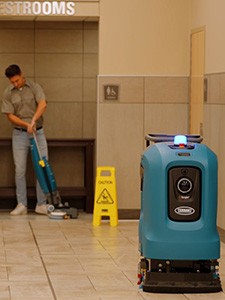 cleaning staff using Tenant T2 walk behind floor scrubber to clean department store entry way cleaning staff using Tenant T2 walk behind floor scrubber to clean department store entry way