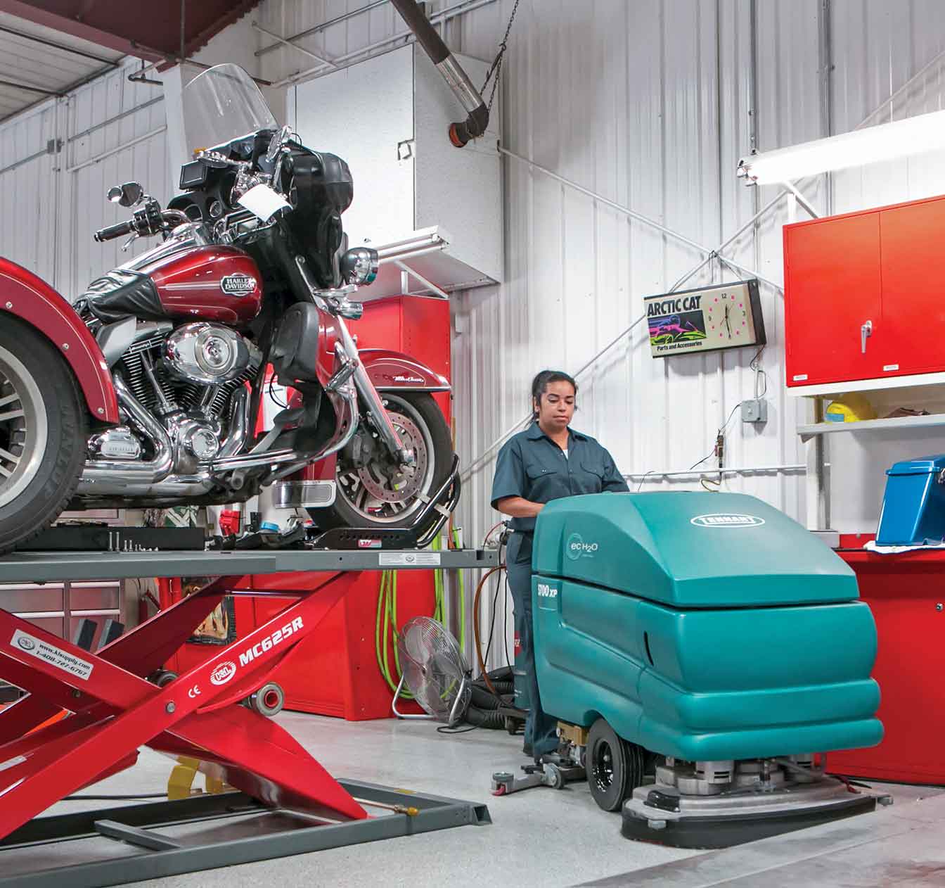 Une récureuse à commande arrière 5700 nettoyant un atelier de réparation automobile.