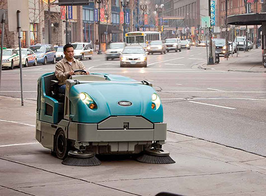 Balai mécanique autoporté de taille moyenne S30 nettoyant les trottoirs d’une ville.