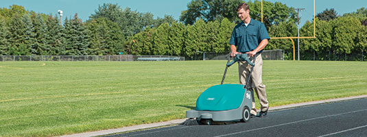 Tennant S5 walk-behind sweeper being used on running track Tennant S5 walk-behind sweeper being used on running track