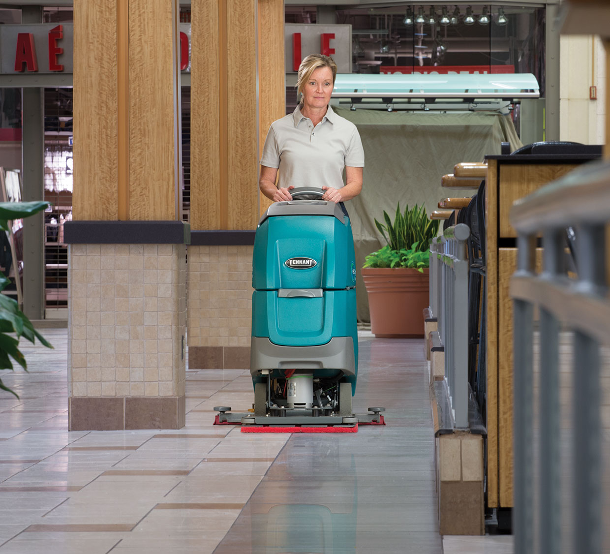 An orbital machine cleans a tile floor with grout lines