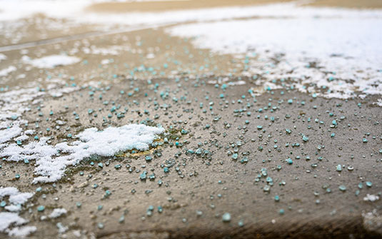 blue salt rock on black asphalt walkway blue salt rock on black asphalt walkway