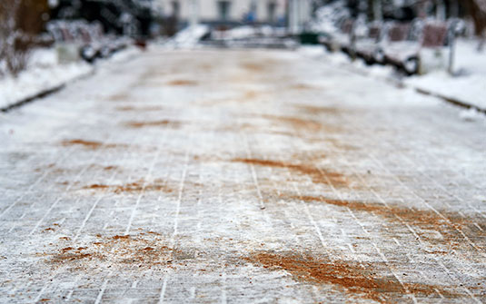 brown sand and kitty litter mixture sprinkled on sidewalk as an alternative to salt