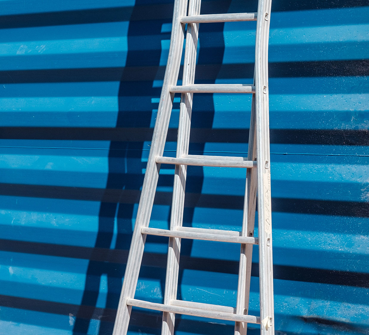 Ladder against blue wall Ladder against blue wall