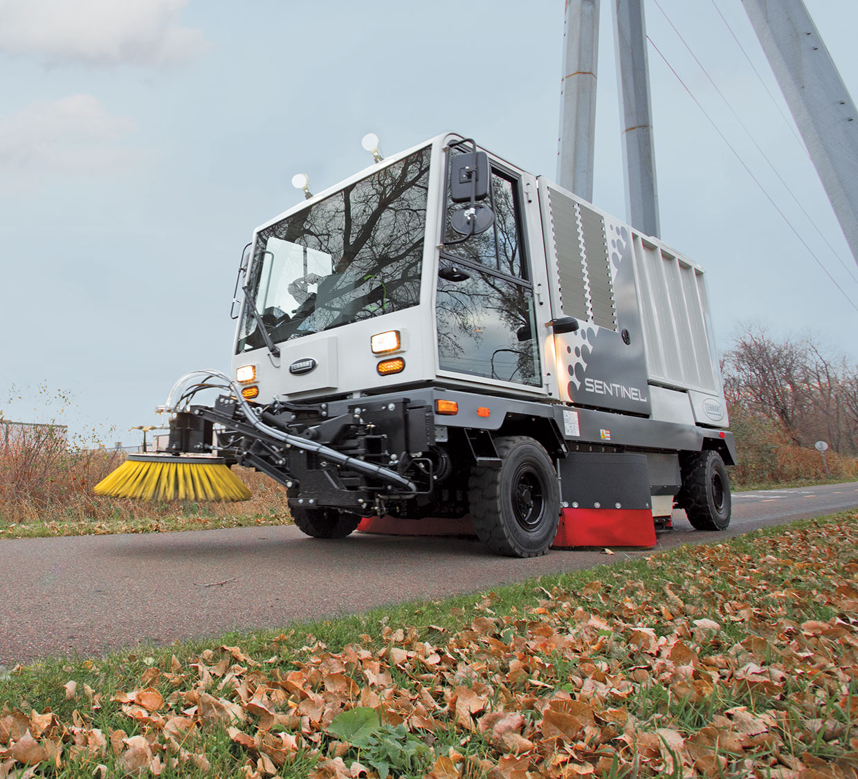 Sentinel Rider sweeper cleaning outdoors in autumn Sentinel Rider sweeper cleaning outdoors in autumn
