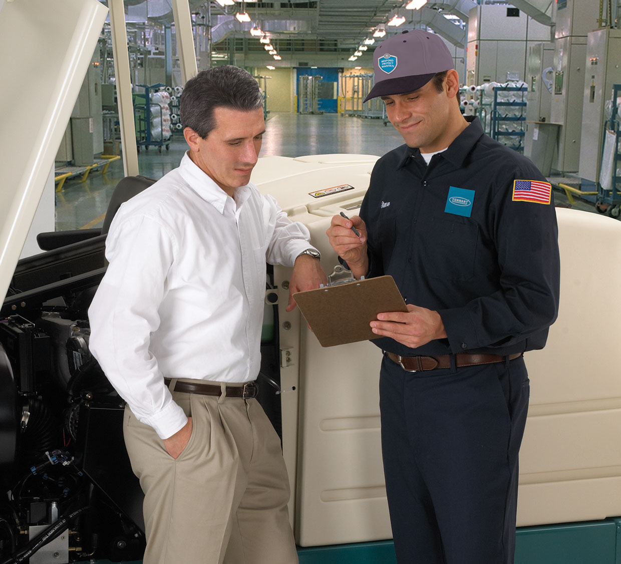 A cleaning equipment service specialist talks to a customer A cleaning equipment service specialist talks to a customer
