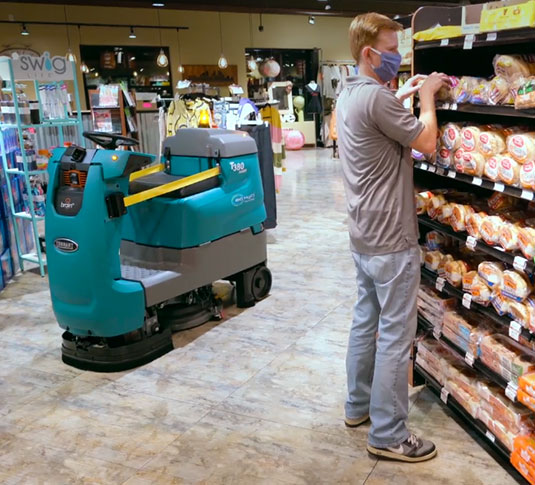 Tennant robotic floor scrubber cleaning aisle in grocery store Tennant robotic floor scrubber cleaning aisle in grocery store