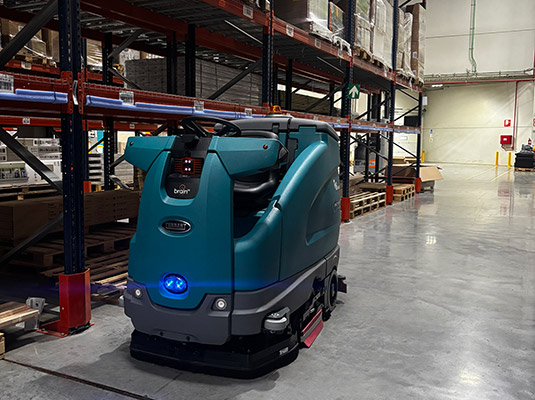 Robot autónomo de limpieza T16AMR mientras limpia un almacén