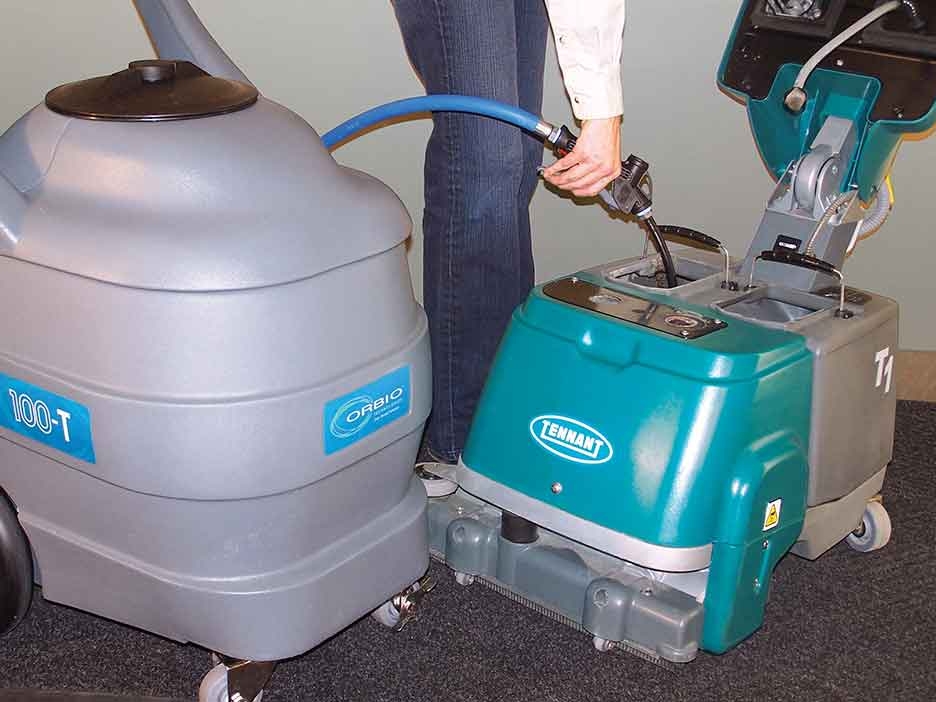 Un chariot de transport de solution Orbio remplit une récureuse T1 Tennant Un chariot de transport de solution Orbio remplit une récureuse T1 Tennant