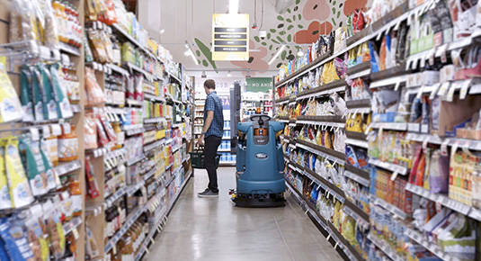 Robotische schoonmaakmachine die in een supermarkt schoonmaakt