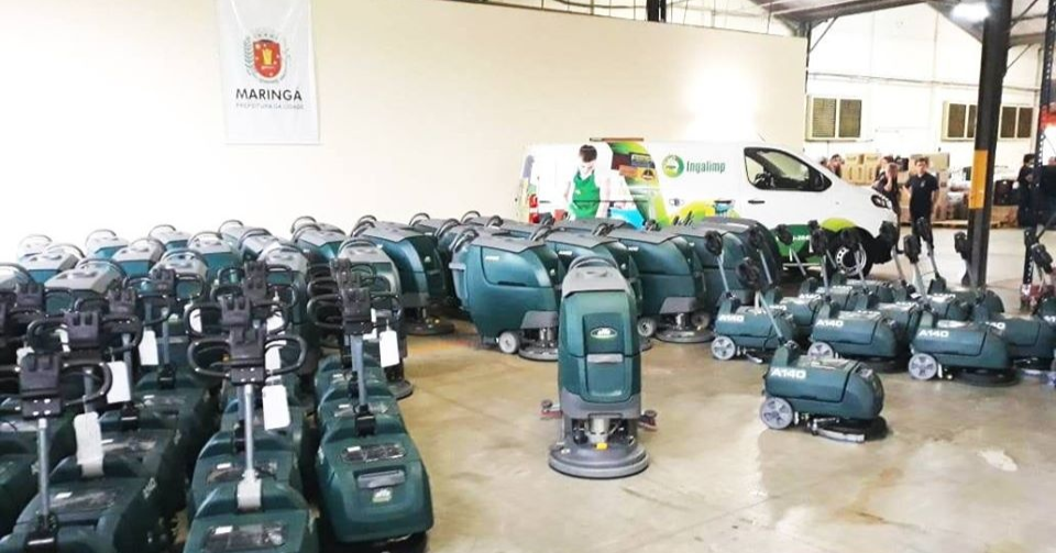 Uma trabalhadora efetua a manutenção de um pavimento de betão polido com uma auto lavadora. Uma trabalhadora efetua a manutenção de um pavimento de betão polido com uma auto lavadora.